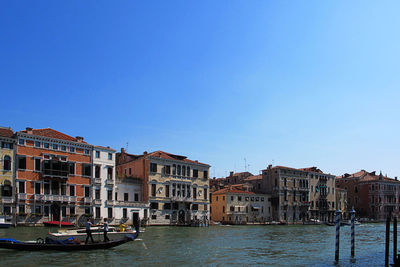 Canal amidst buildings against sky in city