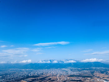 Aerial view of landscape against blue sky