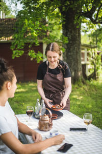 Smiling customer talking with waitress at outdoor cafe