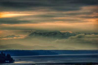 Scenic view of sea against dramatic sky during sunset