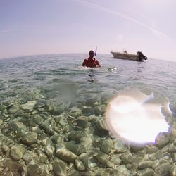 Man surfing in sea against sky