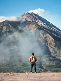 Rear view of man standing on mountain