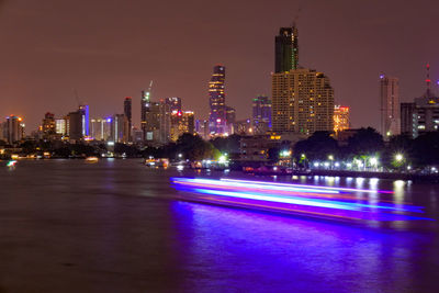 Illuminated buildings against sky at night