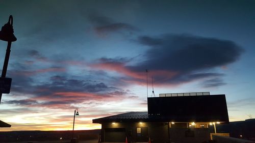 Low angle view of silhouette buildings against sky at sunset