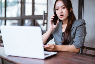 Young woman using laptop at table