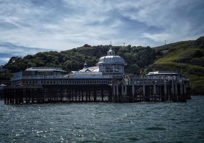 Built structure by sea against sky