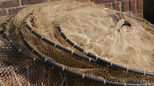 Fishing net drying against brick wall