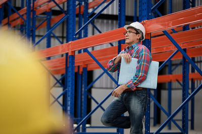 Man looking away while standing by railing