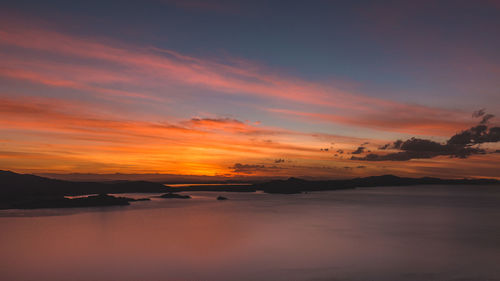 Scenic view of sea against dramatic sky during sunset