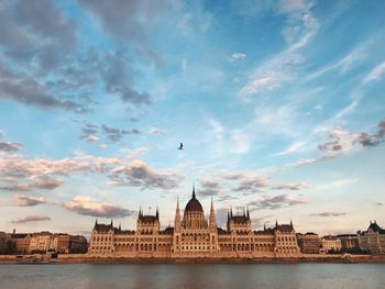 View of building and river against cloudy sky