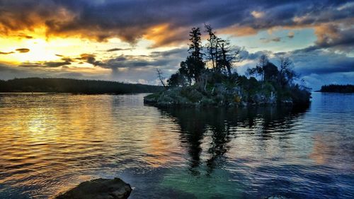 Scenic view of lake against sky at sunset