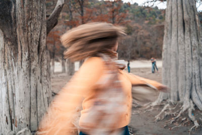 Blurred motion of woman walking on tree trunk