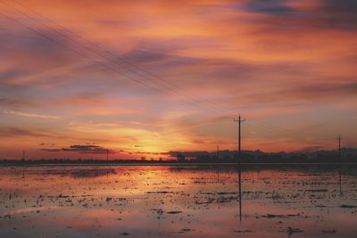 Scenic view of lake against orange sky