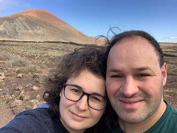 Portrait of smiling couple standing on landscape 