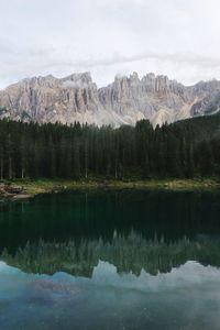 Scenic view of trees and rocky mountains reflection in lake against sky