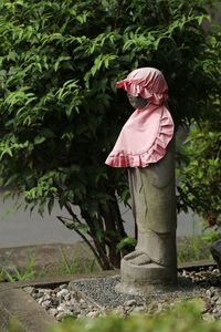 Side view of woman standing by tree