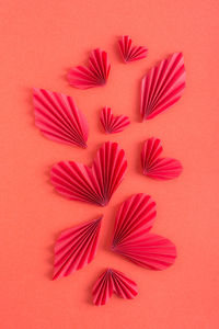 Vertical red background with origami hearts and leaves. monochrome concept