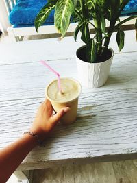 Close-up of hand with drink on table