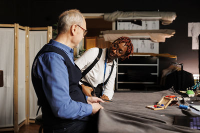 Side view of man using digital tablet while sitting at home