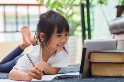 Portrait of smiling girl sitting on table