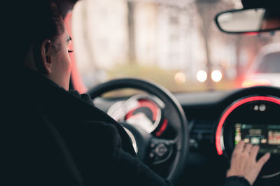 Midsection of man seen through car windshield