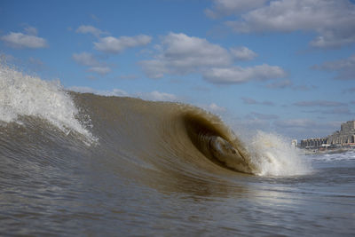 Water splashing in sea against sky