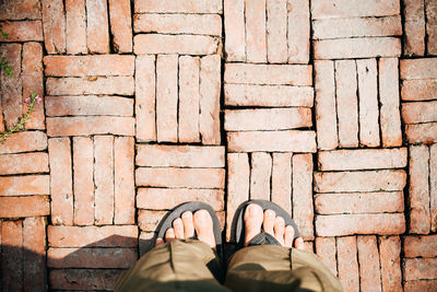 Low section of man standing on tiled floor