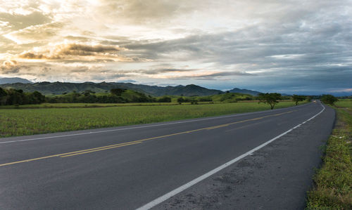 Road passing through land against sky