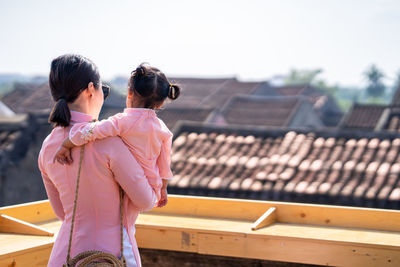 Mother and daughter with vietnam culture traditional dress standing at the rooftop in hoi an.