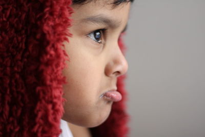 Close-up of upset boy wearing headscarf