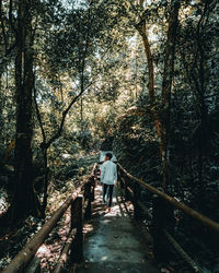 Rear view of man walking in forest