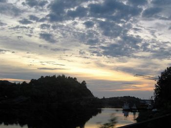 Scenic view of river against cloudy sky