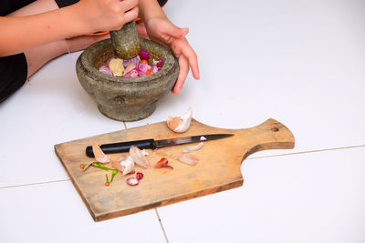 Cropped hand of woman preparing food in mortar and pestle