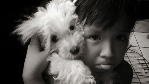 Close-up portrait of girl puckering while holding dog at home