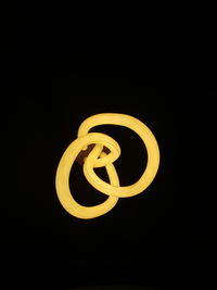 Close-up of illuminated light bulb against black background