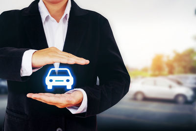 Digitally generated image of man holding car