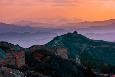 Scenic view of great wall of china on mountain against sky during sunset