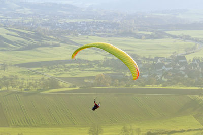 Person paragliding over landscape