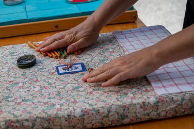 Cropped hands of woman painting on table