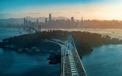 High angle view of bridge over river by buildings against sky