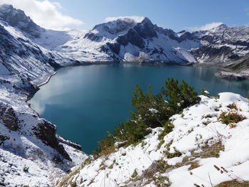 Scenic view of lake and snowcapped mountains against sky