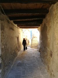 Rear view of man walking in tunnel