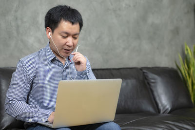 Man looking away while sitting on mobile phone