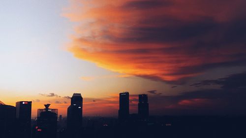 Modern cityscape against sky during sunset