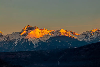 Scenic view of snowcapped mountains against sky during sunset