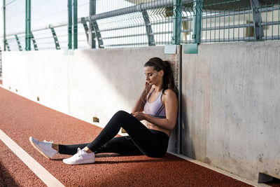 Young woman sitting on running track