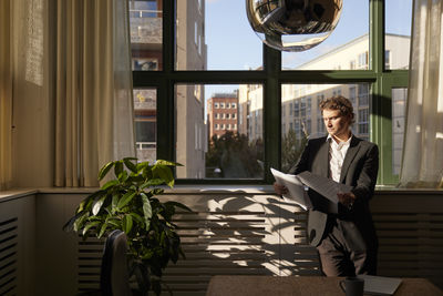 Portrait of young woman sitting on sofa at home