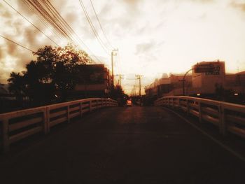 Bridge over city against sky during sunset