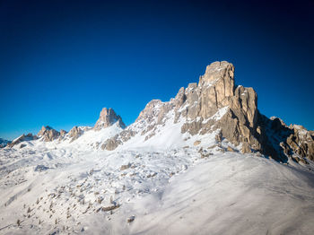 Scenic view of snowcapped mountains against clear blue sky