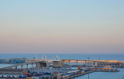 Boats moored at harbor against clear sky